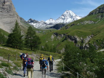 Rear view of hikers hiking on mountains in winter