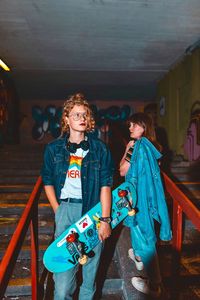 Portrait of young woman standing against wall