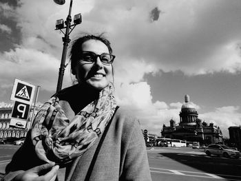 Man with umbrella on street against sky in city