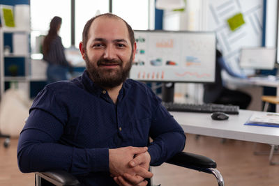 Portrait of young man standing in office