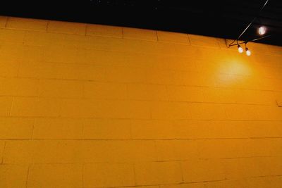 Low angle view of illuminated yellow light