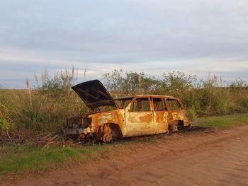 Abandoned truck on field against sky