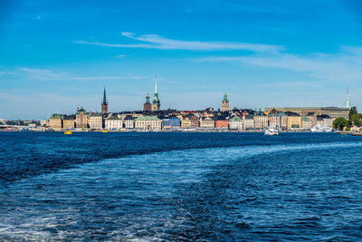 View of sea and buildings against blue sky