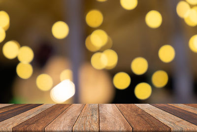 Defocused image of illuminated lights on wooden table