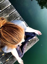 High angle view of woman sitting by lake