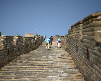 Low angle view of people at great wall of china against clear sky