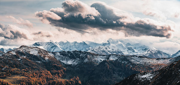 Dramatic sky over snow capped mountains in fall colors, saalbach, salzburg, austria