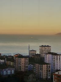 View of cityscape at seaside during sunset