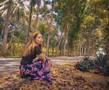 Young woman wearing hat against trees