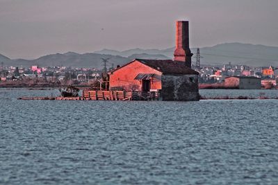 Houses by sea against sky