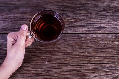 High angle view of hand holding tea cup on table