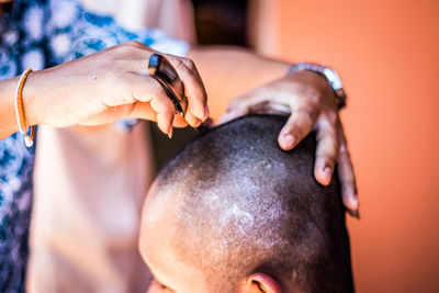 Midsection of man cutting customer hair