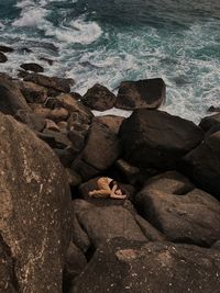 High angle view of the girl in the stones near the sea