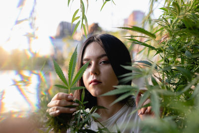 Portrait of young woman amidst plants