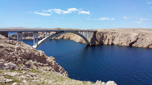 Pag bridge over bay of water against sky