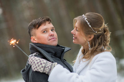 Happy couple with sparklers during winter