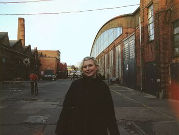 Portrait of woman standing in front of building