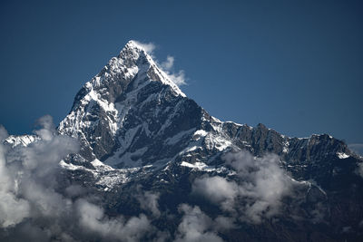 Aerial view of snowcapped mountains against clear blue sky