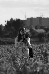 Young woman on field against sky