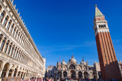 View of buildings in city against blue sky