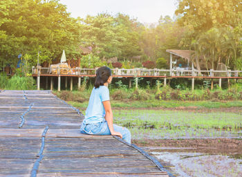 Side view of girl playing on grass against trees