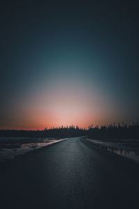 Road against clear sky during sunset