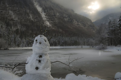 Close-up of snow on landscape against sky during winter