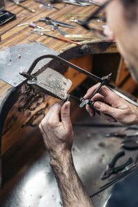 Stock photo of concentrated man working with tools in artisan workshop