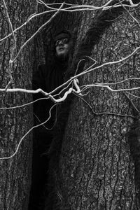 Portrait of woman on tree trunk in forest