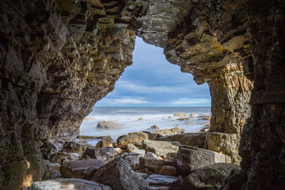 Scenic view of sea seen through cave