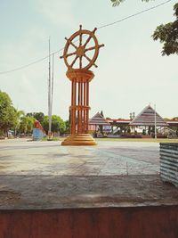 Gazebo in park by building against sky