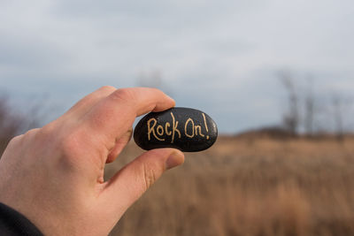 Close-up of text on stone being held by person