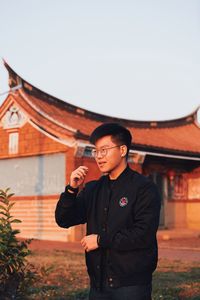 Full length of young man standing against wall