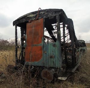 Abandoned truck on field against sky