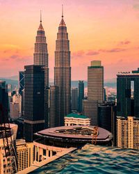 Skyscrapers in city against sky during sunset