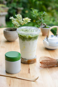 Iced matcha latte in the glass on wooden table