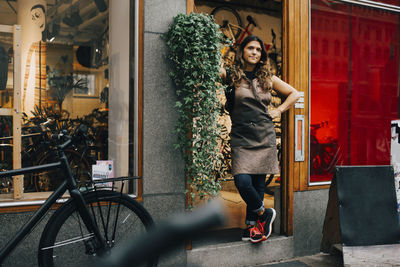 Full length portrait of woman with bicycle