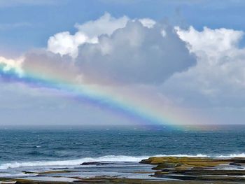 Scenic view of rainbow over sea against sky