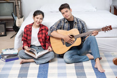 Young couple playing guitar at music concert