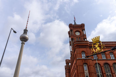 Low angle view of rotes rathaus against cloudy sky