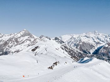 Scenic view of snowcapped mountains against clear blue sky