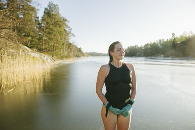 Smiling woman wearing swimwear at river