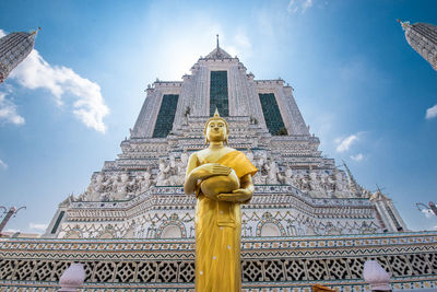 Low angle view of statue against building against sky