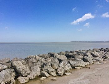 Scenic view of rocks on beach against sky