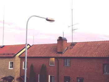 Street light on building against sky