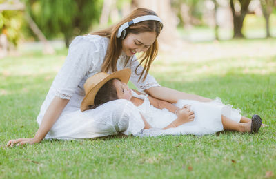 Woman sitting on grass in field