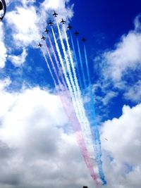 Low angle view of airplane flying against cloudy sky