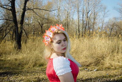 Woman wearing flowers on grassy field