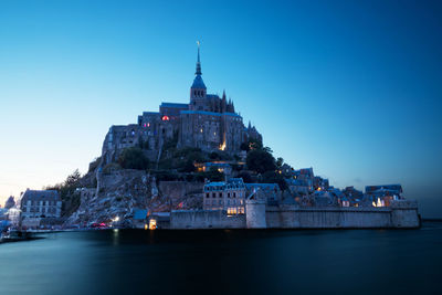 Mont-saint-michel, normandie, france captured during the high tide at blue hour
