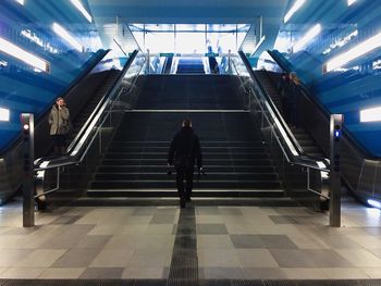 Full length of woman walking on escalator